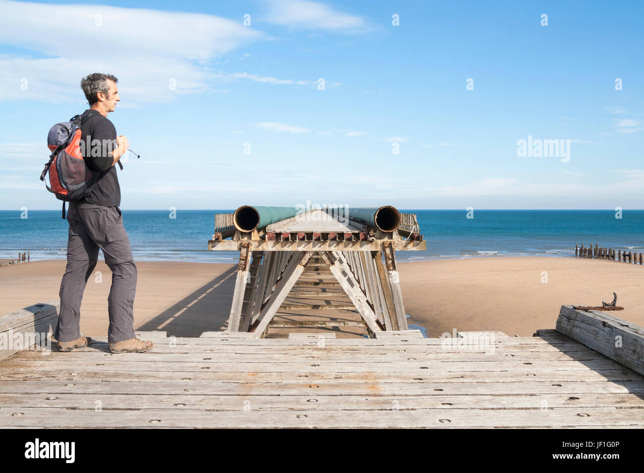 Wanderer zu Fuß stehenden England Küste Weg auf Abschnitt Steetley Pier auf North Sands Beach an der Landzunge, Hartlepool, England. UK Stockfoto