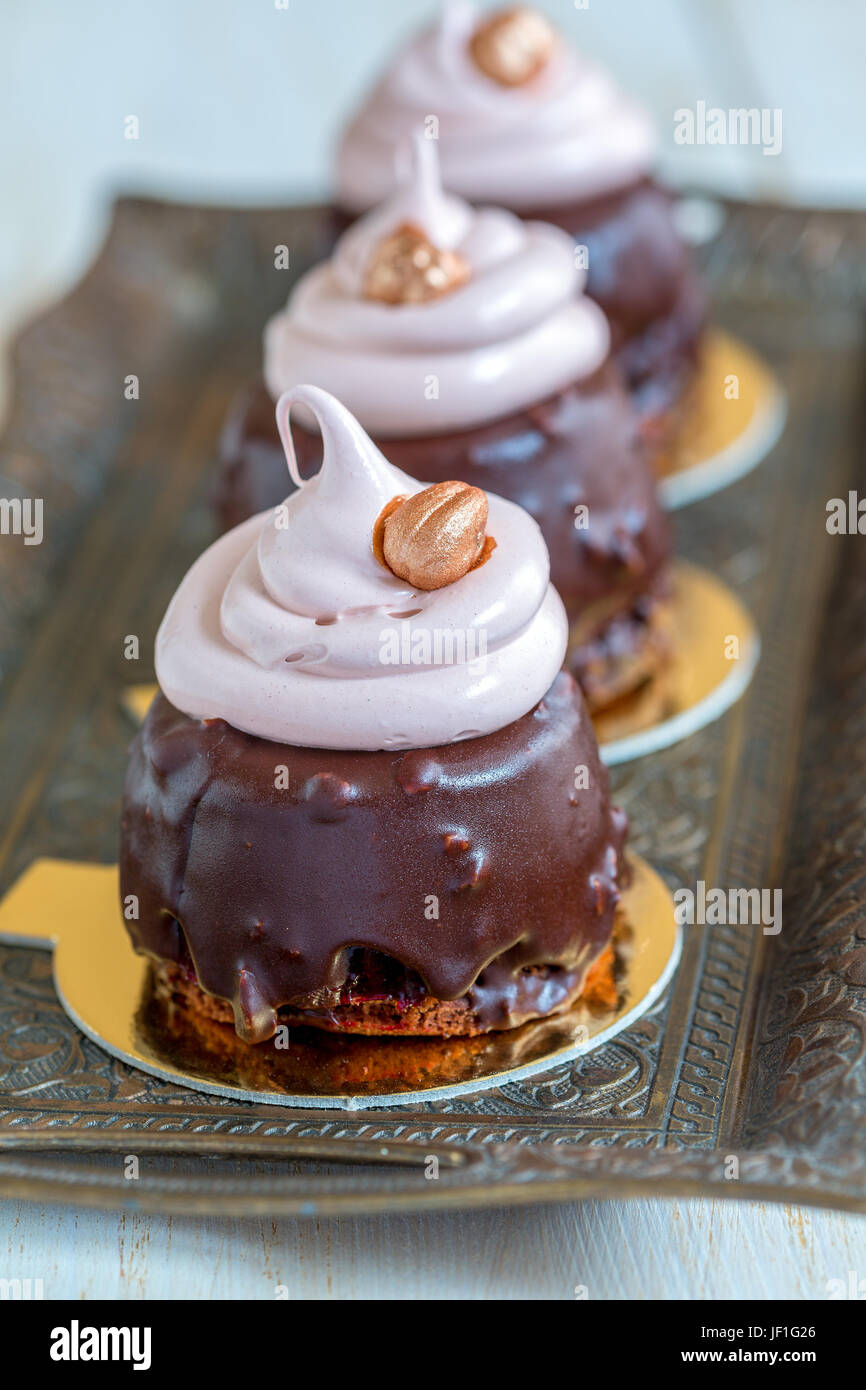 Cupcakes mit Schokolade Zuckerguss, Baiser und Haselnuss. Stockfoto