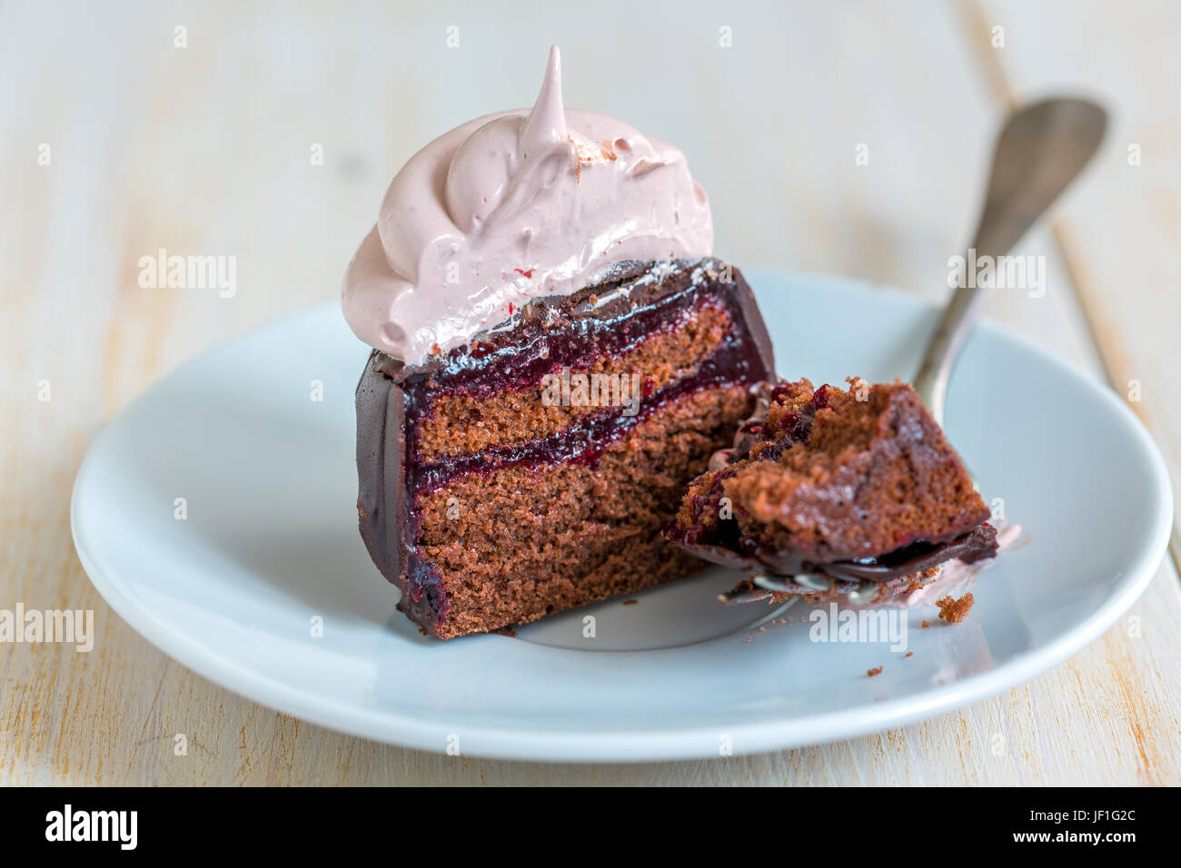 Schoko Cupcakes mit Berry Confit und Schweizer Meringue. Stockfoto