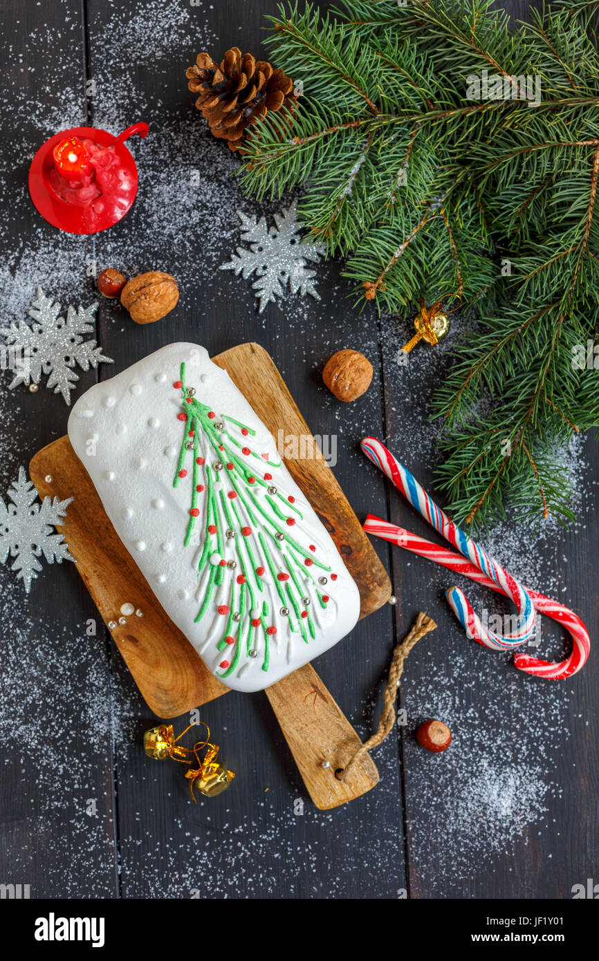 Weihnachten Kuchen, Süßigkeiten, Schneeflocken und eine brennende Kerze. Stockfoto