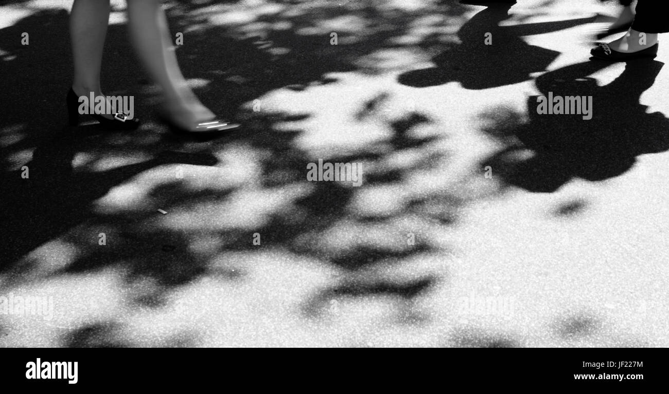 Verschwommen Menschen Silhouette und Schatten auf Stadt Bürgersteig, in schwarz und weiß Stockfoto