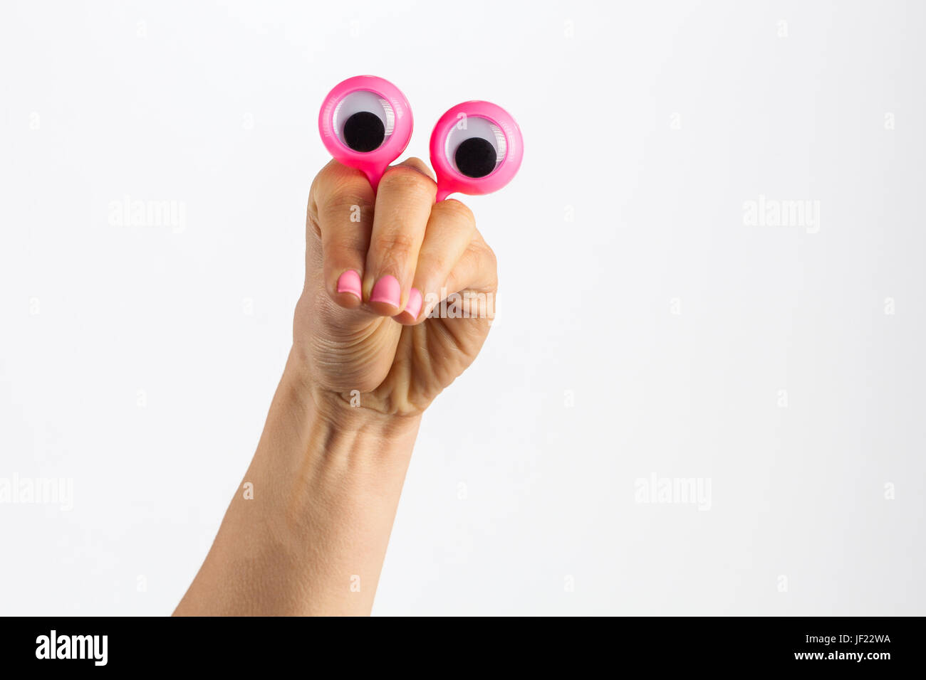 Lustiger Charakter Kreatur suchen Betrachtung und nachdenklich dargestellt mit weiblichen Hand und Googly Augen. Isoliert auf weiss mit Textfreiraum Stockfoto