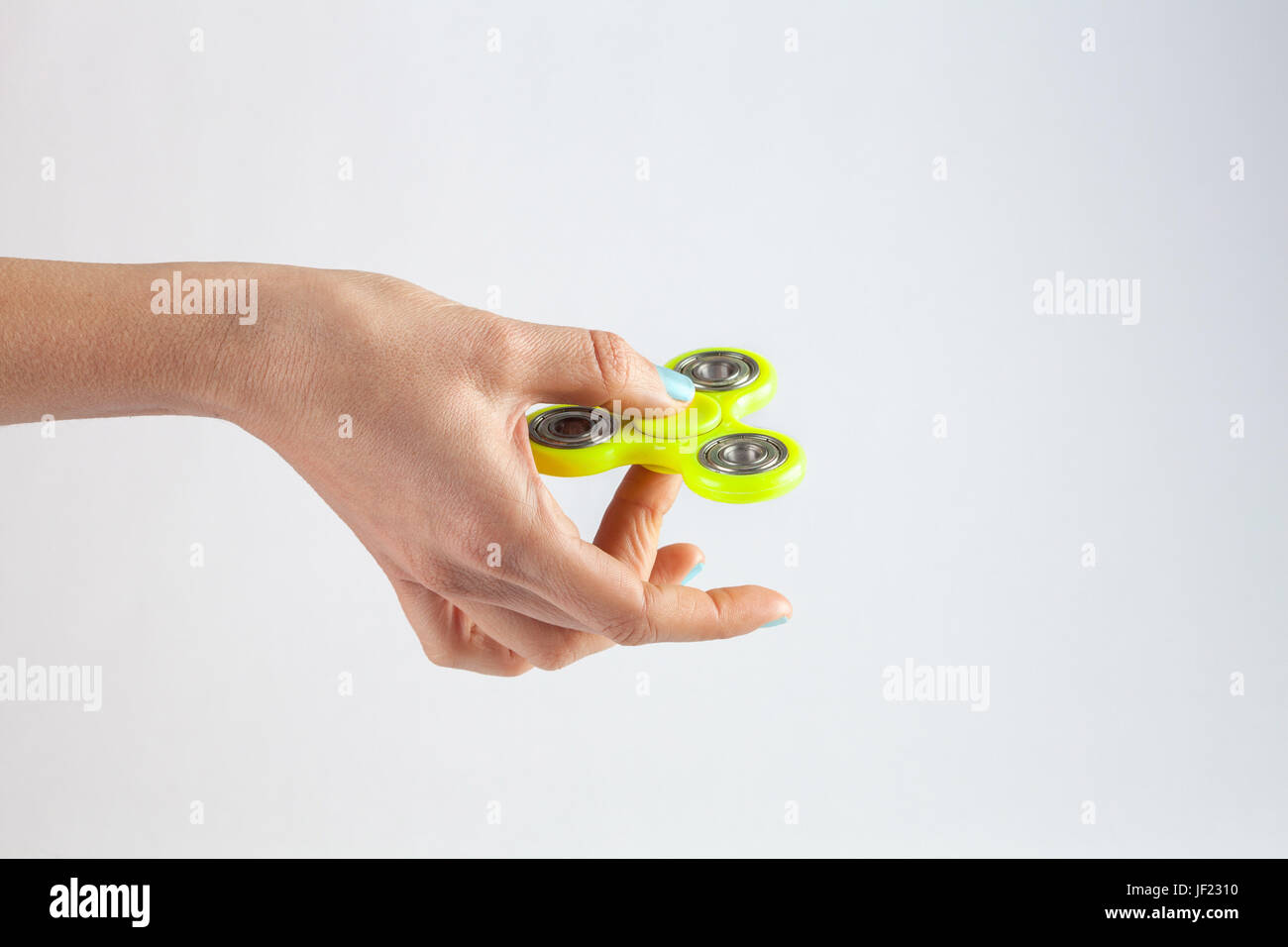 Weibliche Hand Holding gelb zappeln Spinner isoliert auf weißem Hintergrund mit Textfreiraum Stockfoto