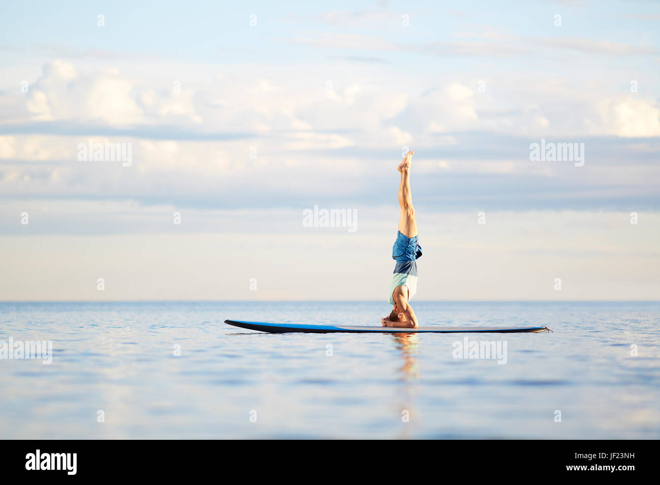 Mann tut Yoga am paddleboard Stockfoto