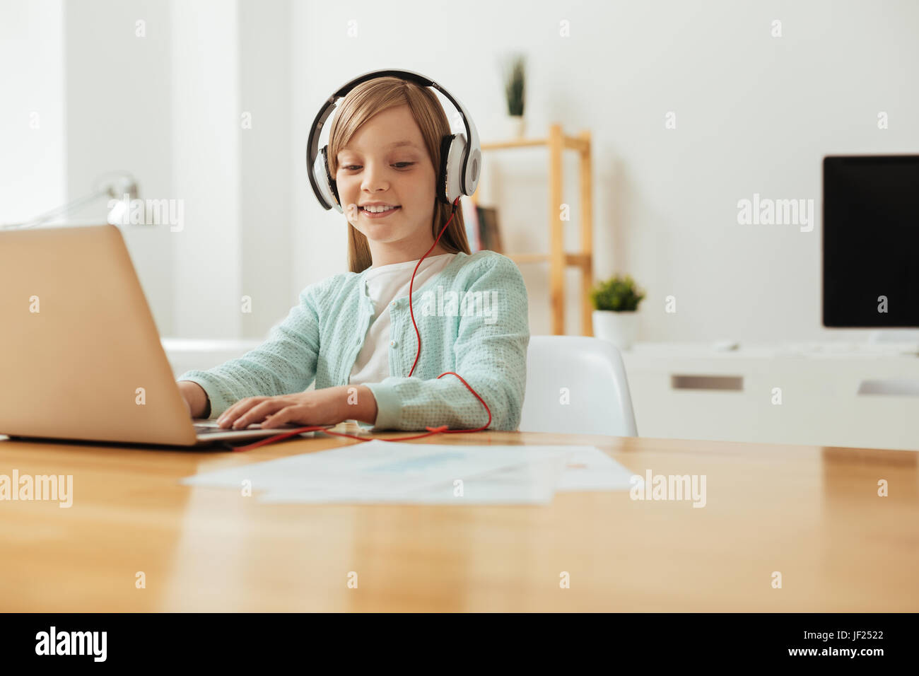 Inspiriert lebendiges Mädchen Musikhören während des Studiums Stockfoto