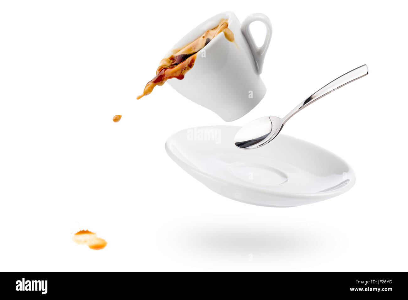 Tasse Kaffee Spils mit Untertasse und Löffel und Kaffee fällt auf weißem Hintergrund Stockfoto
