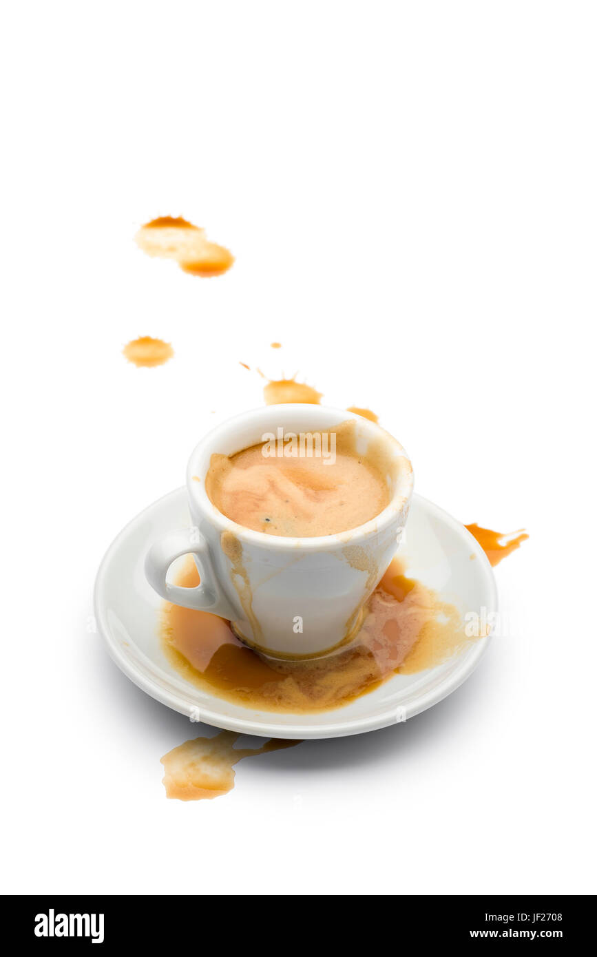 volle Tasse Kaffee mit Kaffee verschüttet auf der Untertasse und auf dem weißen Tisch. Stockfoto