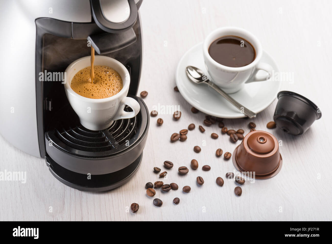 Kaffeemaschine in Betrieb auf Tisch, Kaffeetasse und Kaffeeautomaten. Stockfoto