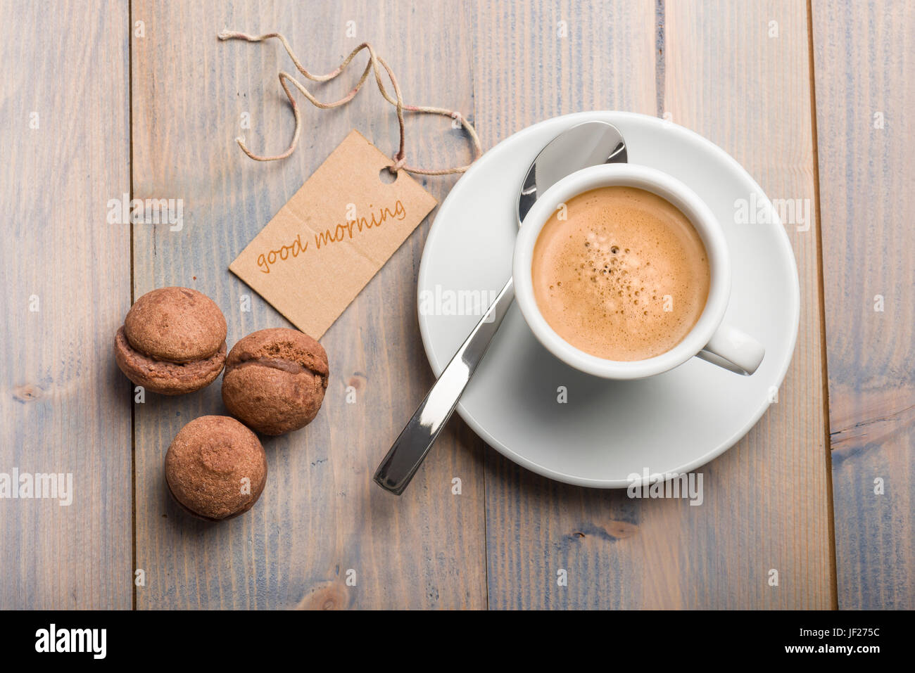 Tasse Kaffee auf Holztisch mit Schokoladen-Cookies und Karte, die guten Morgen sagt. Stockfoto