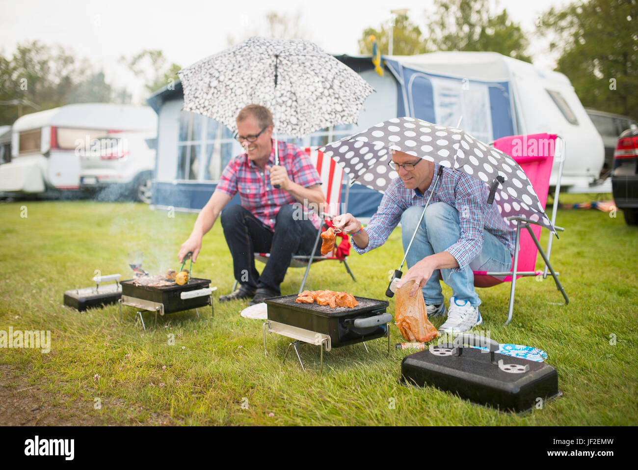 Männer Grillen in Regen Stockfotografie - Alamy
