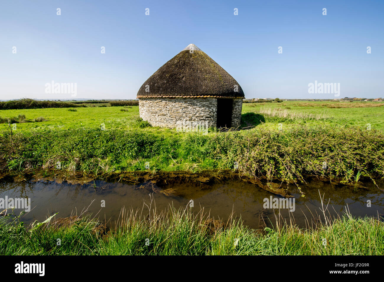 Ein kleines, reetgedeckten, rundes Farmgebäude in Braunton Burrows, North Devon Stockfoto