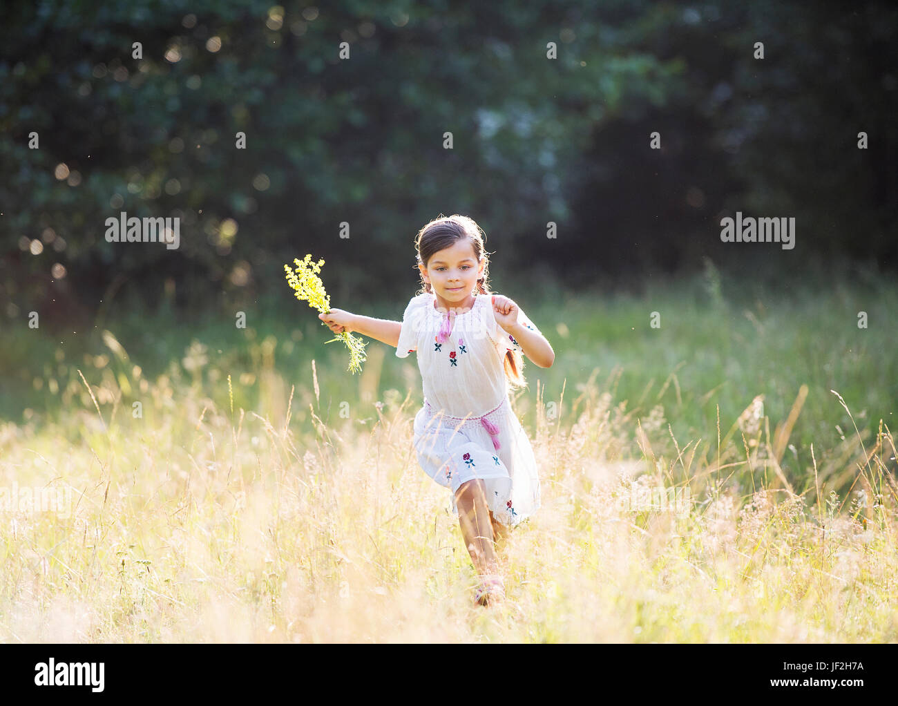 glückliches Mädchen mit engen Zöpfe tragen traditionelle rumänische Bluse außerhalb laufen Stockfoto