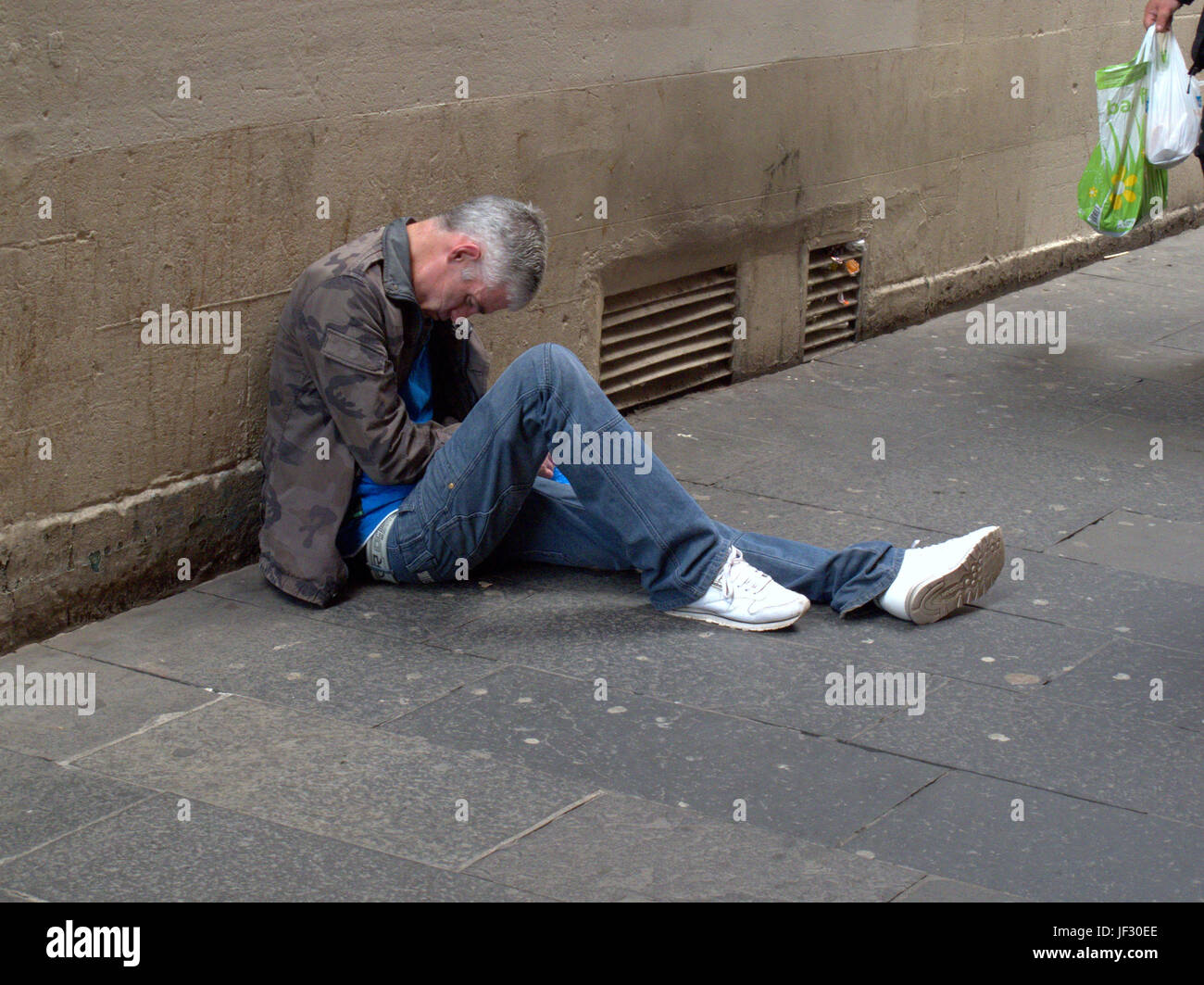 Zombie Droge Spice bettelnden Obdachlosen arbeitslosen Mann lag auf der Straße bewusstlos Stockfoto