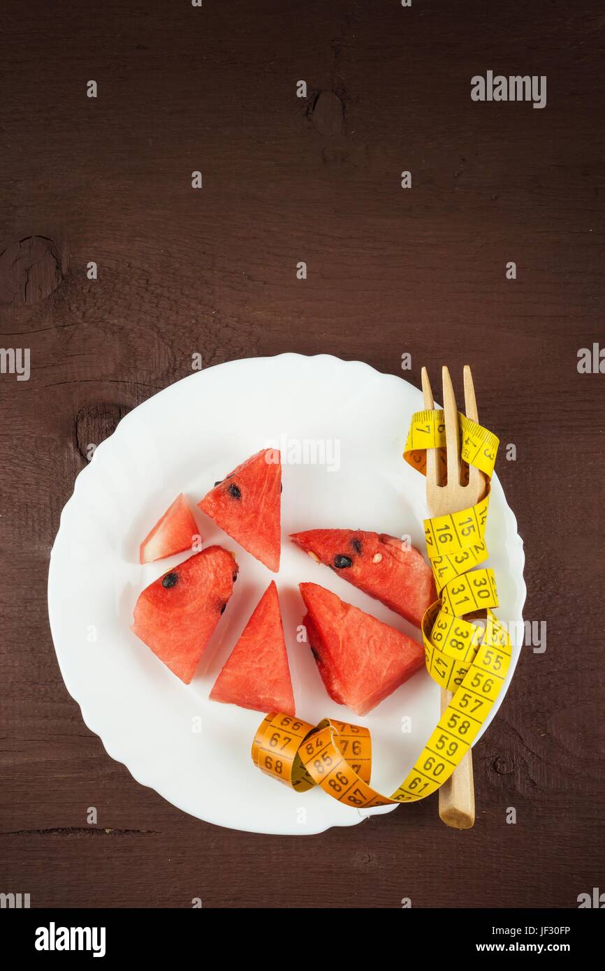 Diätetische Konzept. Melone auf einem Holztisch. Strenge Diät. Reduktion mit Übergewicht Stockfoto