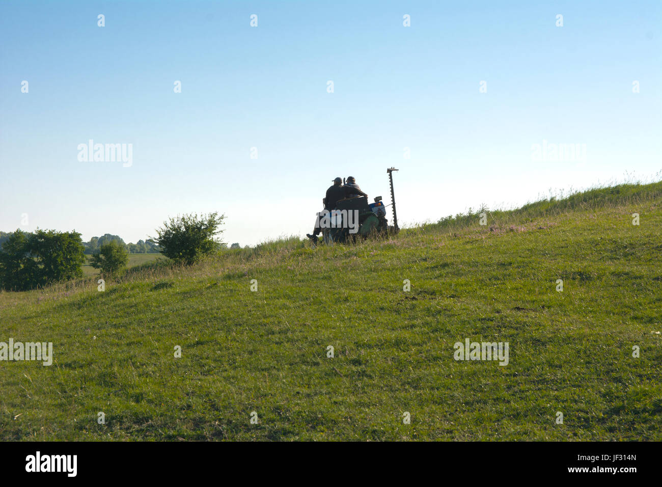 Menschen auf dem Traktor gehen zu arbeiten, um das Land im Feld pflügen Stockfoto