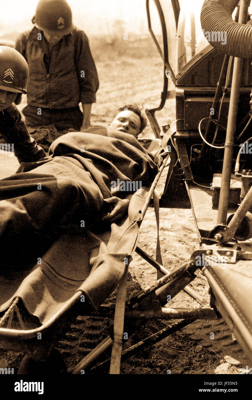 Eine verwundete Amerikaner ist auf einen Hubschrauber bei der 21. inf Regt. Station in Painmal, Korea, eine Meile Sout des 38. Breitengrades, für die Evakuierung zu einem base Krankenhaus sammeln gehoben. 3. April 1951 Stockfoto
