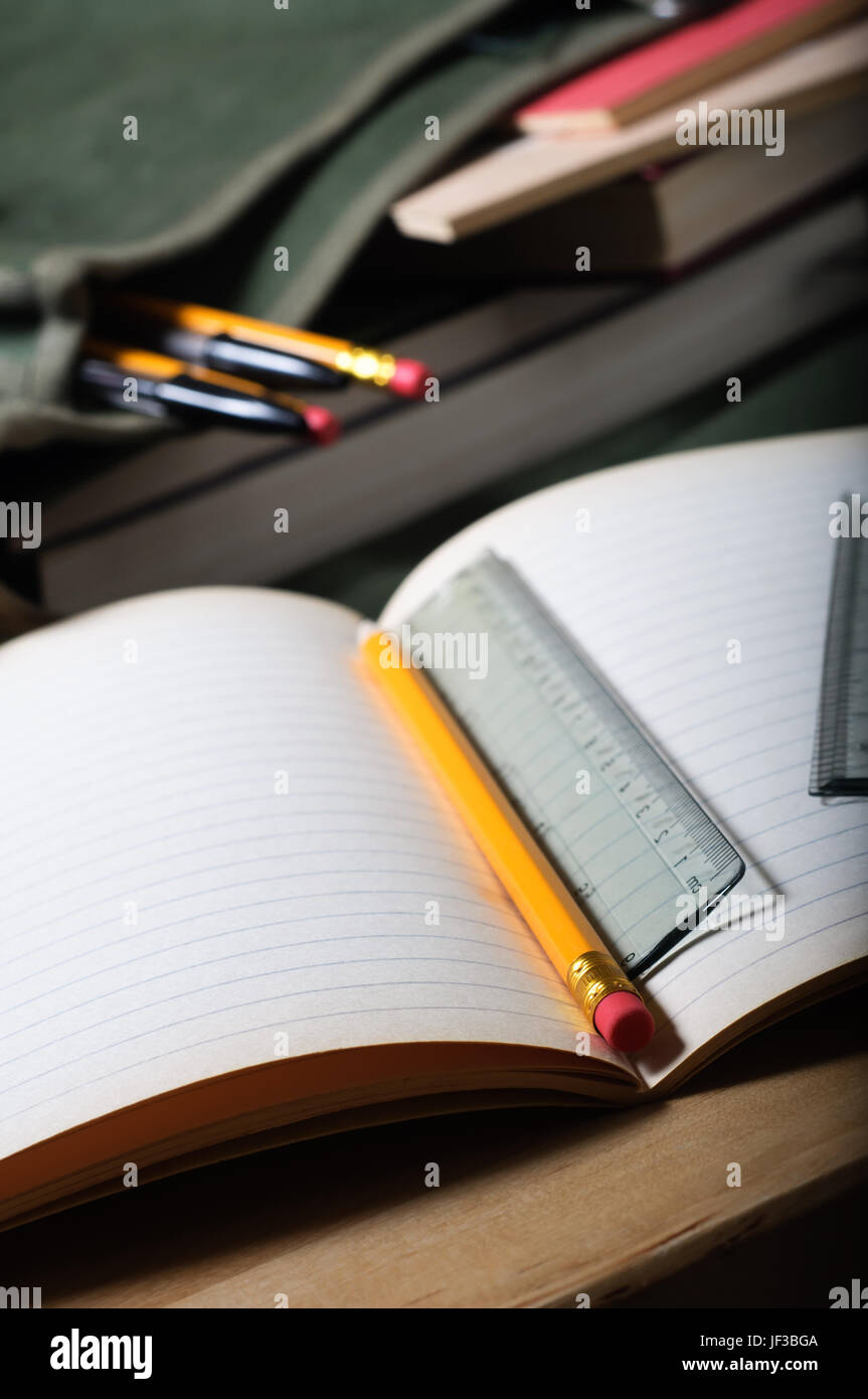 Ein offenes Training Buch auf Tisch mit Bleistift und Lineal.  Offene Beutel im Hintergrund.  Vertikal (Hochformat) Orientierung. Stockfoto