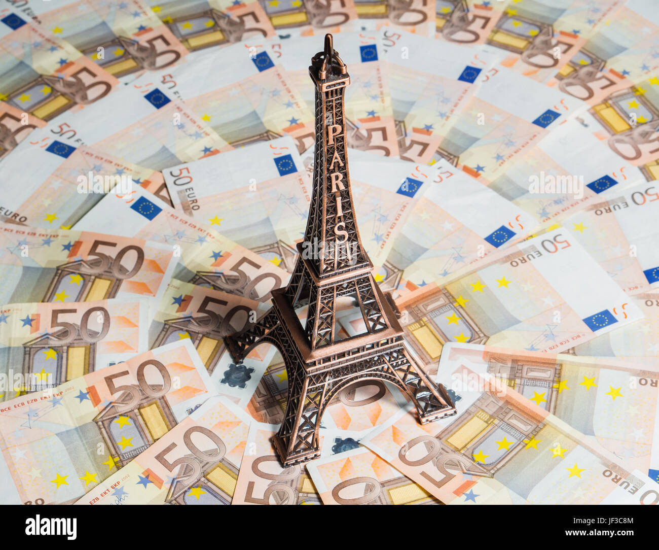 Eiffelturm-Souvenir von Feriengeld umgeben. Ein Großteil der Euro-Scheine. Reise-Budget-Konzept. Stockfoto