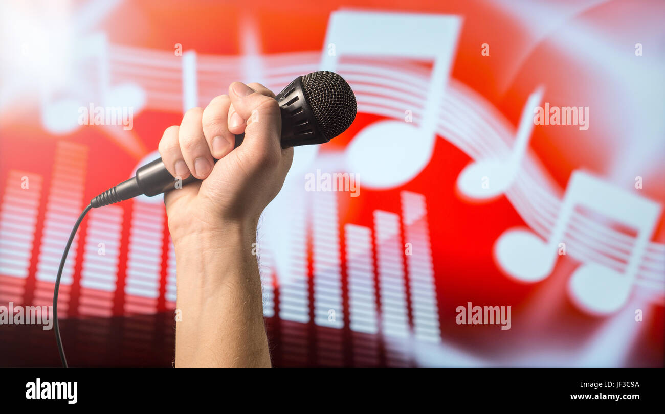 Gesang, Karaoke oder Stimmbildung Konzept. Mikrofon in der Hand vor einem abstrakten Themen Hinweis und Equalizer Hintergrundmusik. Songcontest und li Stockfoto