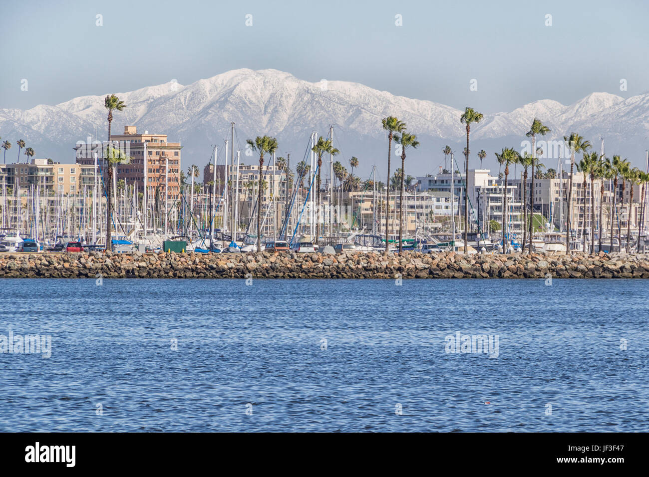 Long Beach, Kalifornien, Hafen und Skyline, mit schneebedeckten San Gabriel Mountains im Hintergrund. Der Hafen von Long Beach. Stockfoto