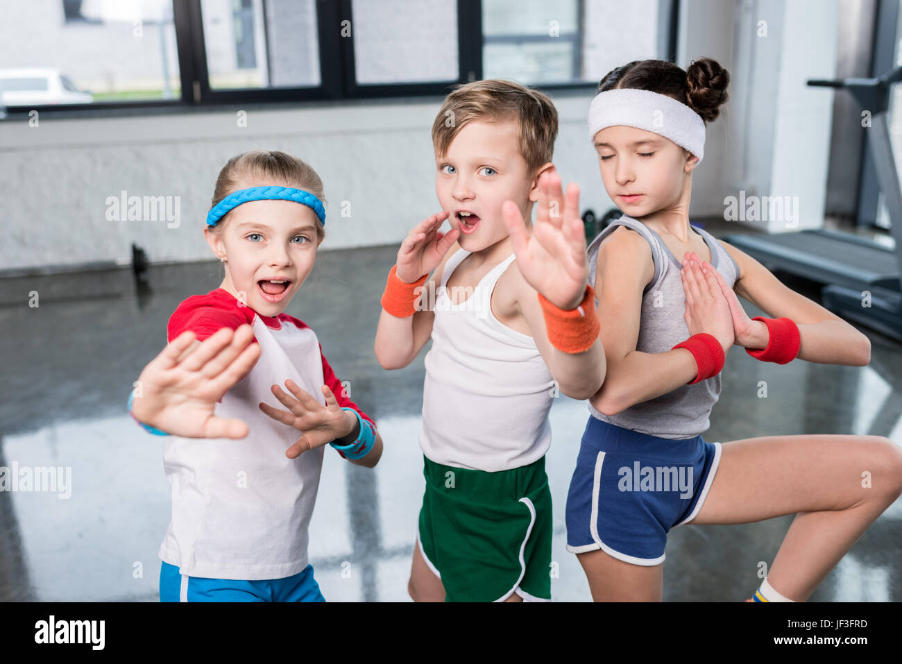 Gruppe von kleinen Kindern in Sportbekleidung ausüben und posiert auf  Kamera im Fitness-Studio, Kinder-Sport-Schule-Konzept Stockfotografie -  Alamy