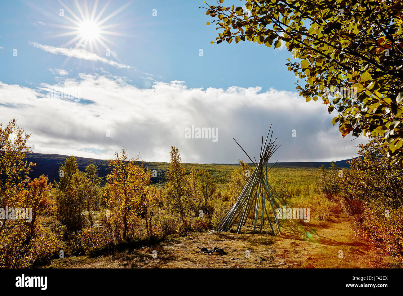 Herbstlandschaft mit Tipi-förmigen Holzstruktur im Vordergrund Stockfoto