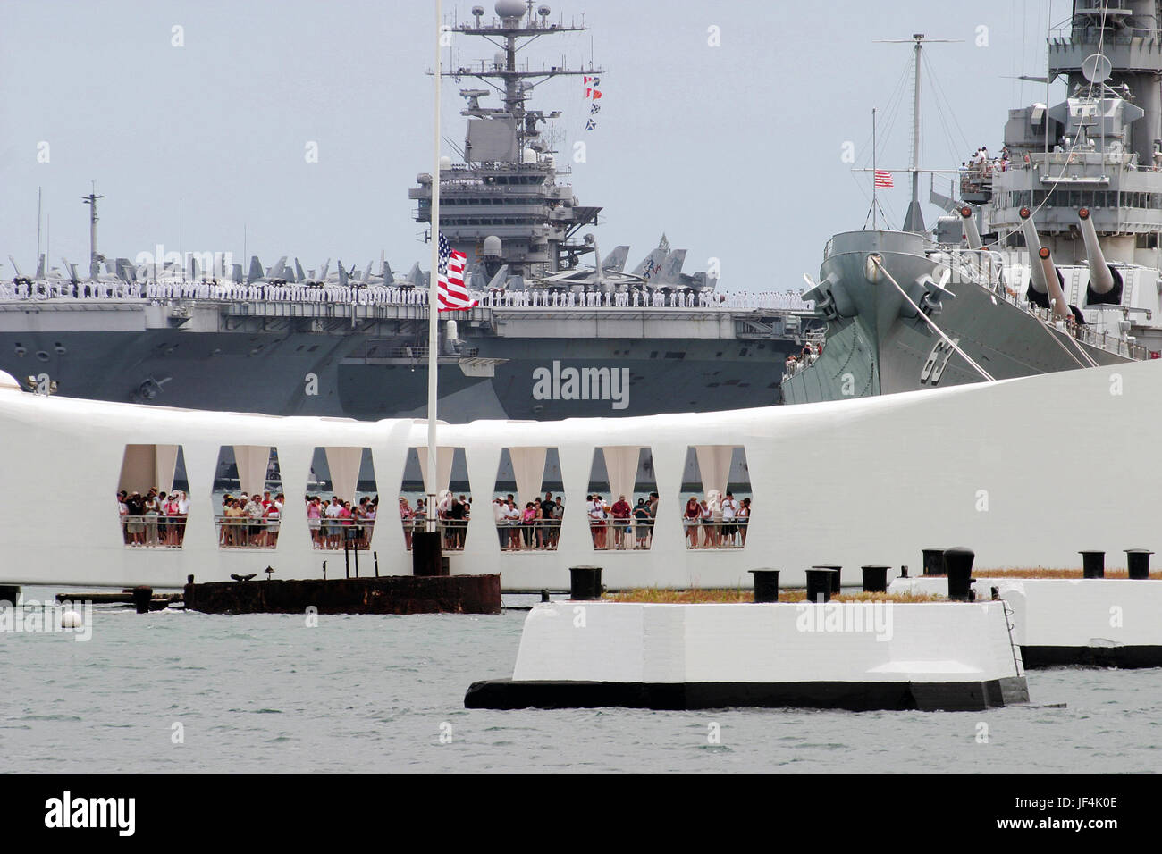 Matrosen an Bord der Flugzeugträger der Nimitz-Klasse USS John C. Stennis (CVN-74) Rendern Ehren, wie sie die USS Arizona Memorial in Pearl Harbor, Hawaii passieren. Foto: U.S. Navy des Fotografen Mate 1. Klasse William R. Goodwin Stockfoto