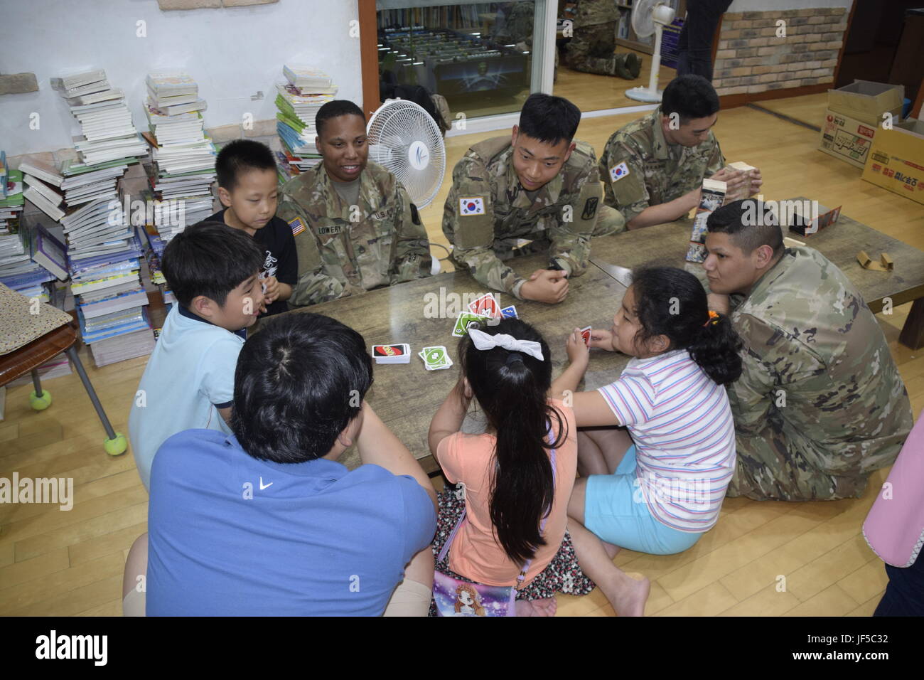 US-Soldaten und Koreanisch Stabsverstärkungskräften, der United States Army zugewiesen, 35. Luft-Verteidigung-Artillerie-Brigade und Kinder aus der Pyeongtaek lokalen Kinderzentrum, spielen ein kompetitives Spiel Karten an das lokale Kinderzentrum Pyeongtaek 30. Mai 2017 während einer Community Outreach Event. Stockfoto