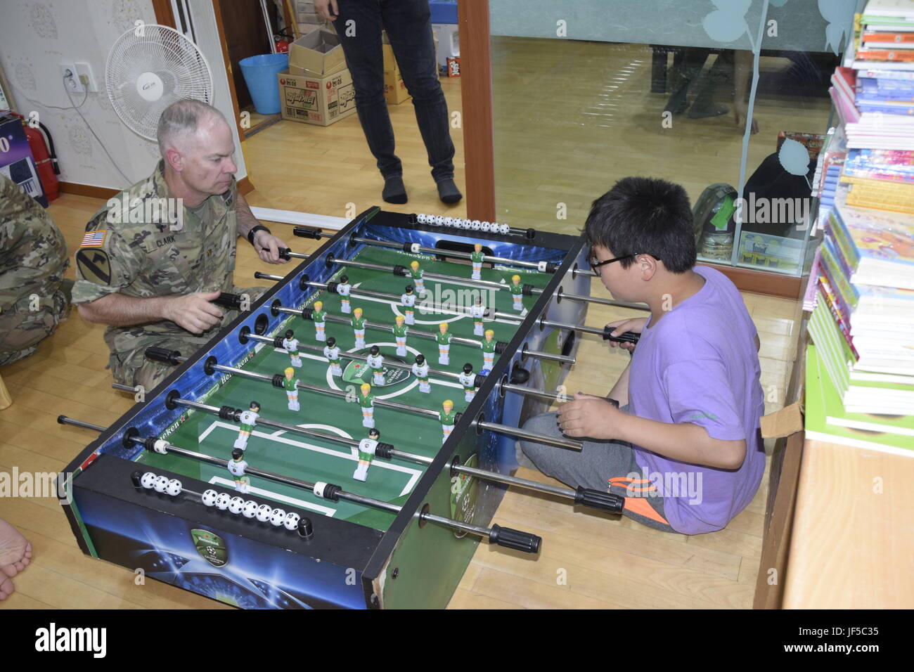 Major Ben Clark, 35. Luft-Verteidigung-Artillerie-Brigade Kaplan, spielt eine Partie Tischfußball gegen ein Kind an das lokale Kinderzentrum Pyeongtaek 30. Mai 2017 während einer Community Outreach Event. Stockfoto