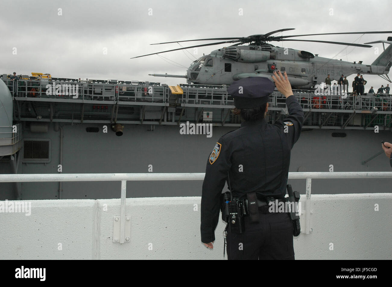 170530-N-RE886-002 NEW YORK (30. Mai 2017) A New York Police Department Offizier Wellen an die Crew der USS Kearsarge am Pier 88 in Manhattan als das Schiff beginnt ihre Abreise, signalisiert das Ende der 2017 Fleet Week New York (FWNY), Mai 30. FWNY, ist jetzt im 29. Jahr der altehrwürdigen Stadtfest Meer Dienstleistungen. Es ist eine einmalige Gelegenheit für die Bürger von New York und Umgebung Tristate-Matrosen, Marines und Küste Gardisten zu erfüllen, als auch Zeuge aus erster Hand die neuesten Möglichkeiten der heutigen maritime Dienstleistungen. (U.S. Navy Photo von Mass Communication Specialist 2n Stockfoto