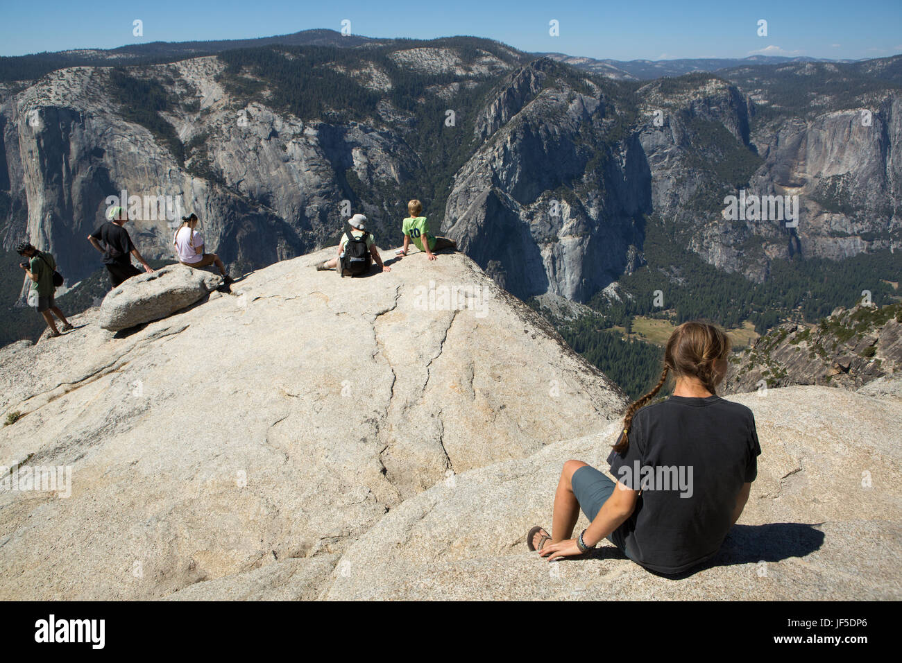 Mehrere Wanderer ruhen auf einem Felsvorsprung in einen Wanderweg, der Ausblick zum Yosemite Tal und El Capitan Taft Point Spitze. Stockfoto