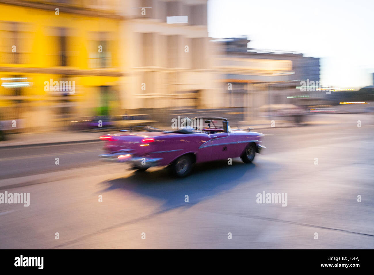 Eine klassische amerikanische Cabrio beschleunigt in einer Straße in der Innenstadt von Havanna. Stockfoto