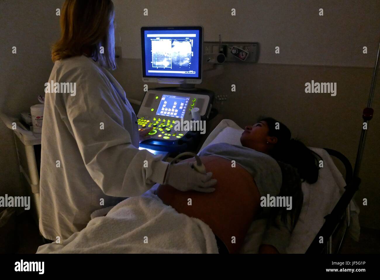 Eine 41-Woche schwanger Hispanic Frau, die eine Ultraschalluntersuchung. Stockfoto