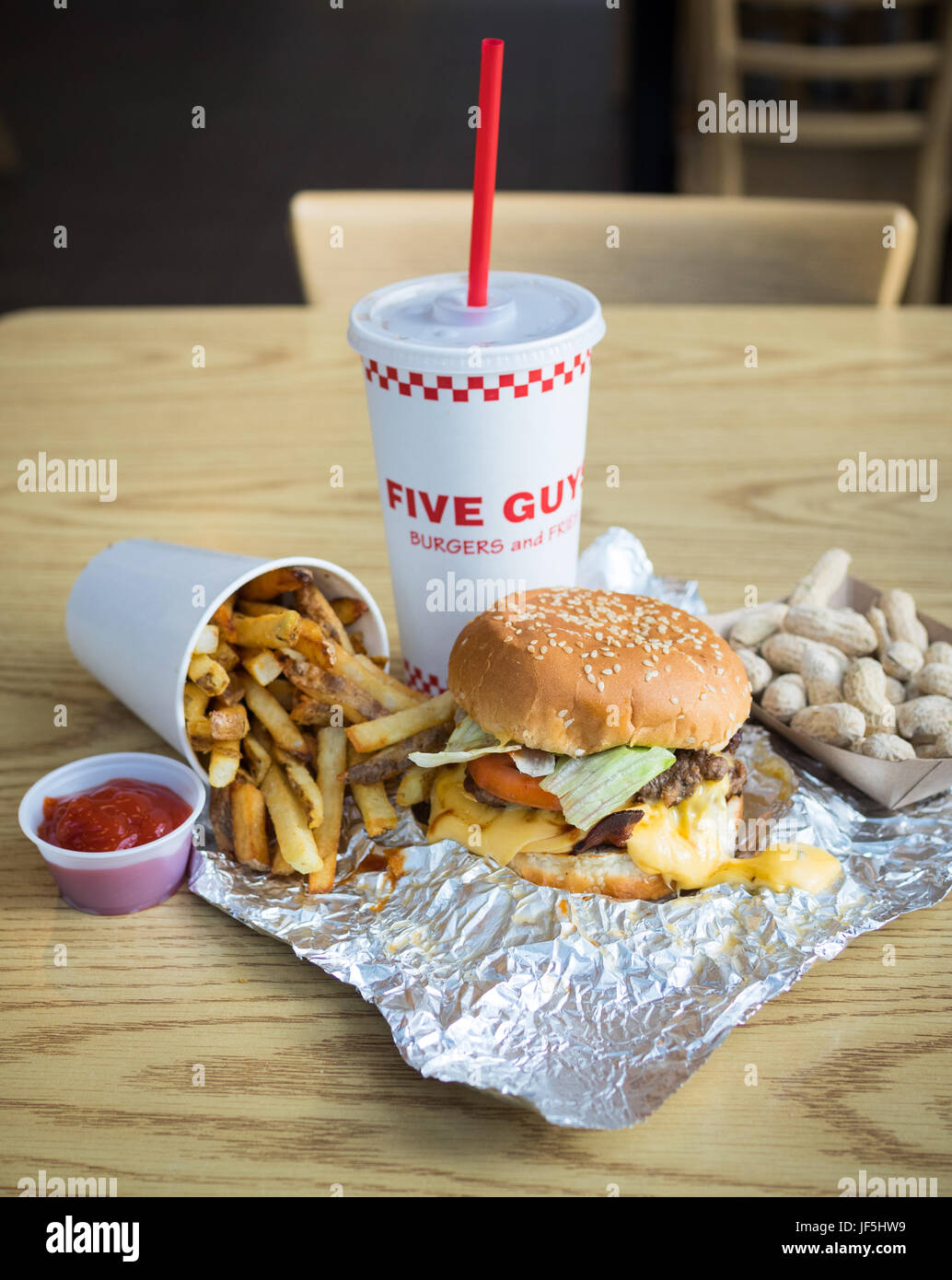 Ein Bacon Cheeseburger, Pommes Frites und Erdnüsse aus fünf Jungs Burger und Pommes, eine amerikanische fast-casual-Restaurant-Kette. Stockfoto