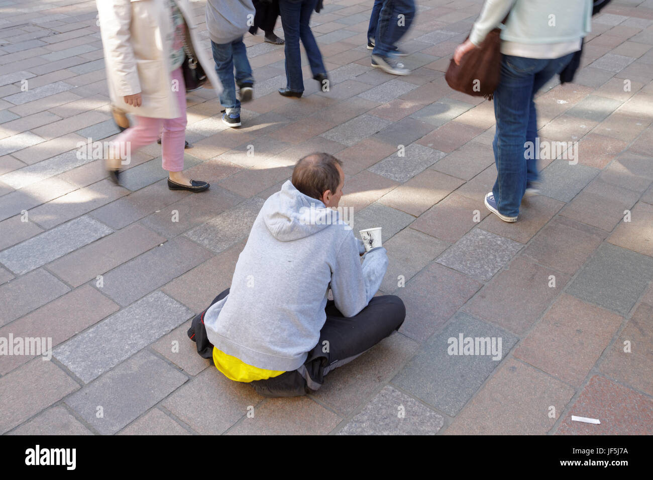 bettelnden Obdachlosen arbeitsloser Mann betteln auf der Straße mit Tasse Menschen zu Fuß durch Stockfoto