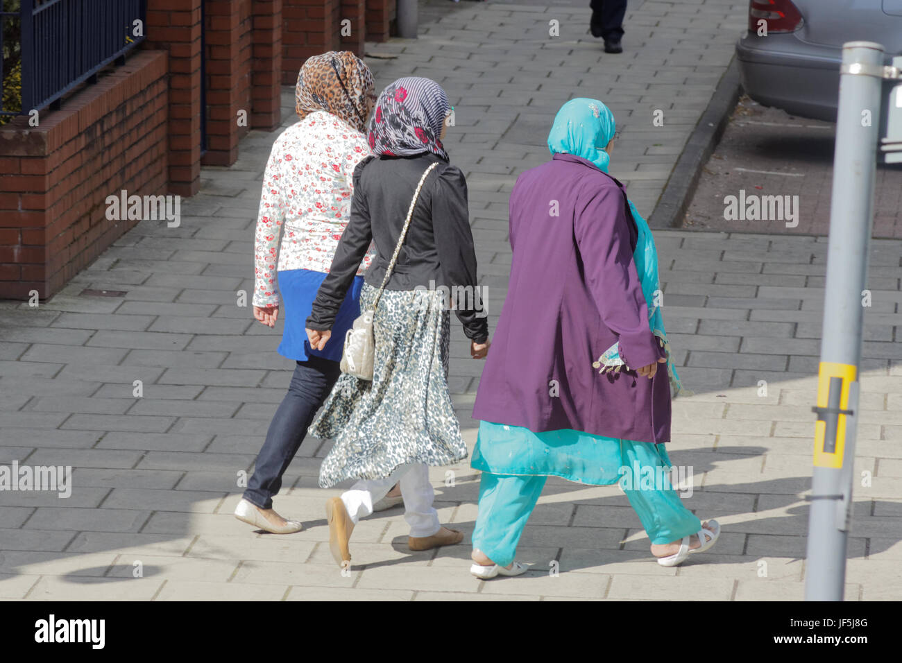 Asiatische Familie Flüchtling gekleidet Hijab Schal auf Straße in der UK alltägliche Szene drei Mädchen einkaufen Stockfoto