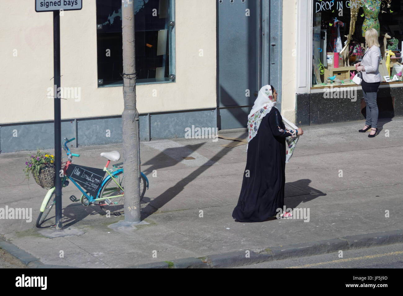 Asiatische Familie Flüchtling gekleidet Hijab Schal auf Straße in der UK alltägliche Szene Frau einkaufen Stockfoto