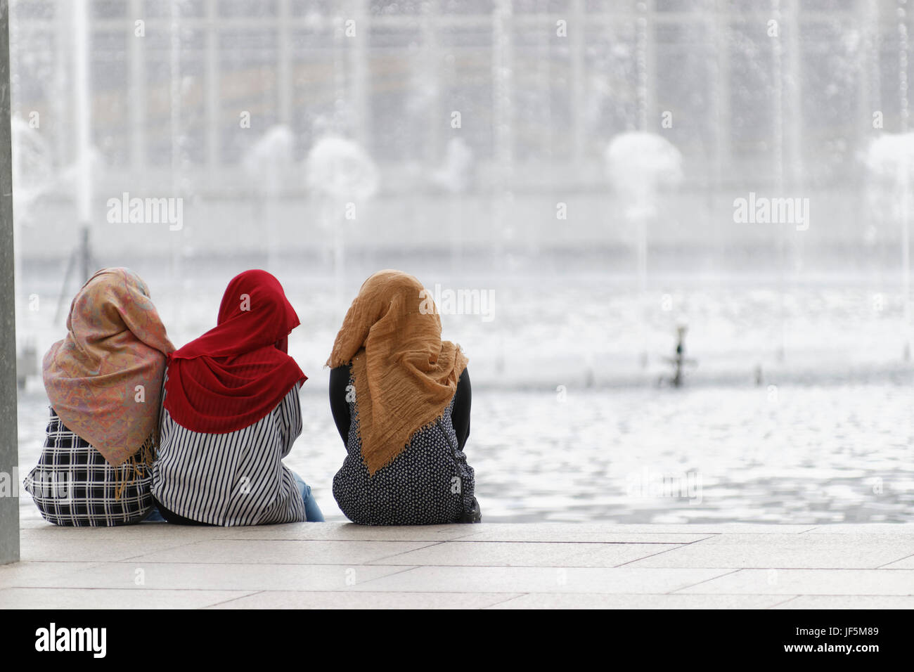 Malaysische muslimische Frauen sitzen und entspannen im KLCC Park in Kuala Lumpur. Stockfoto