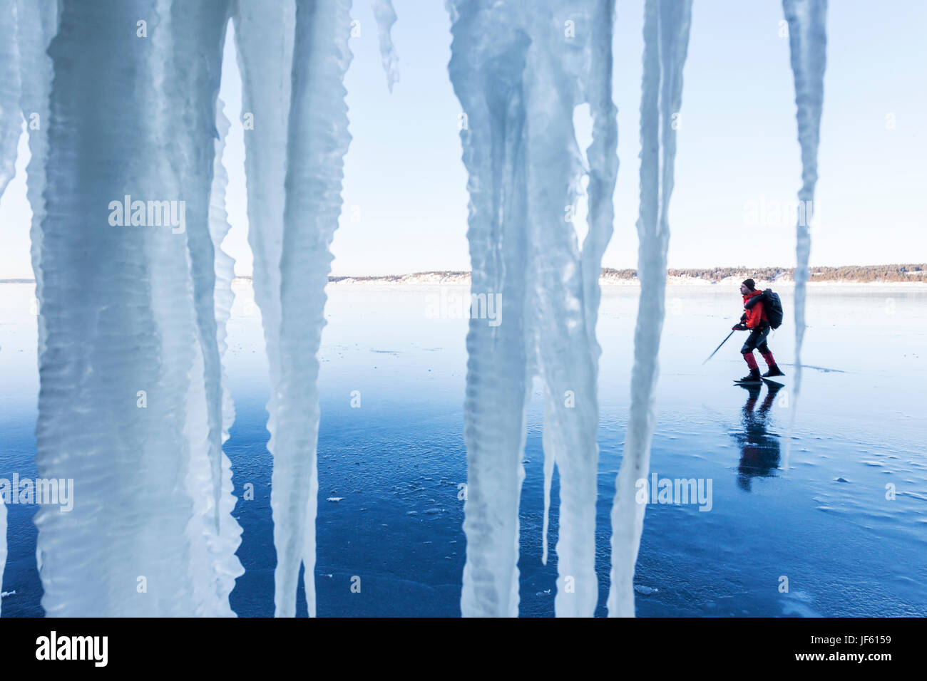 Person Schlittschuhlanglauf. Eiszapfen im Vordergrund Stockfoto