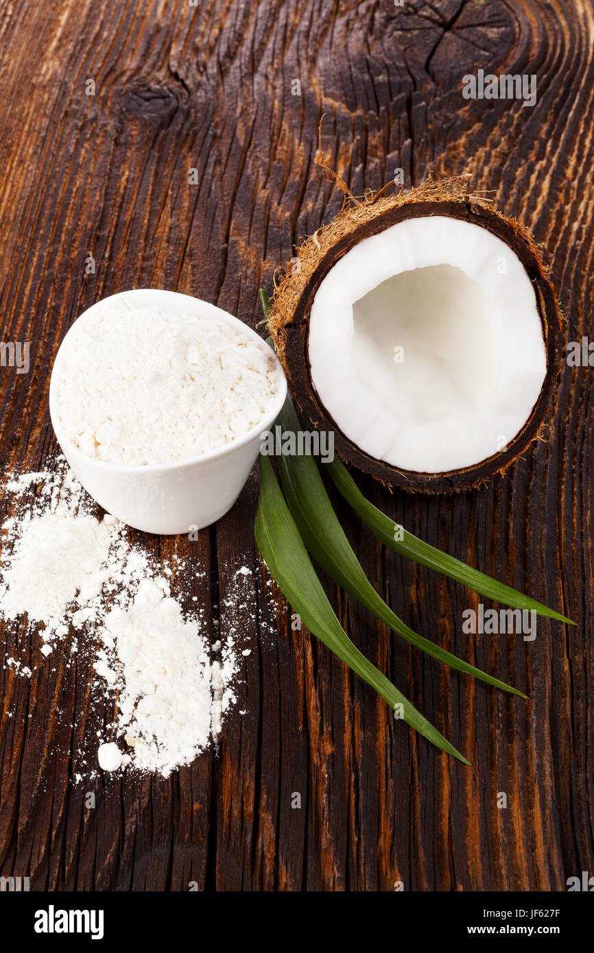 Kokosmehl und frischen Kokosraspeln mit auf Holztisch. Köstliche gesunde Kokosnuss auf dunklem Holz. Stockfoto