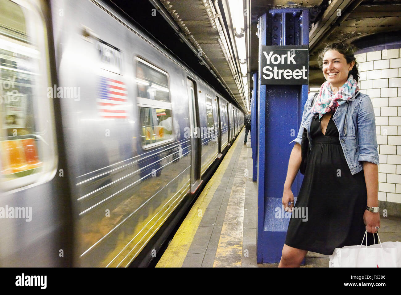 Lächelnde Frau auf u-Bahn-Plattform Stockfoto