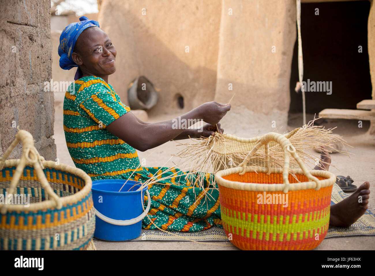 Eine Frau webt traditionelle Strohkörbe in Upper East Region, Ghana. Stockfoto