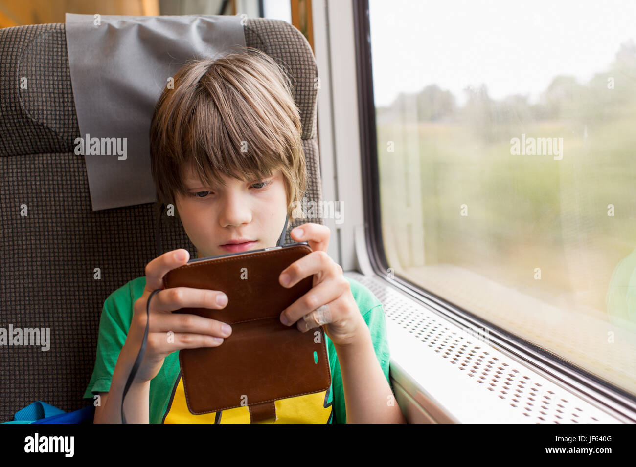 Junge im Zug mit Handy Stockfoto