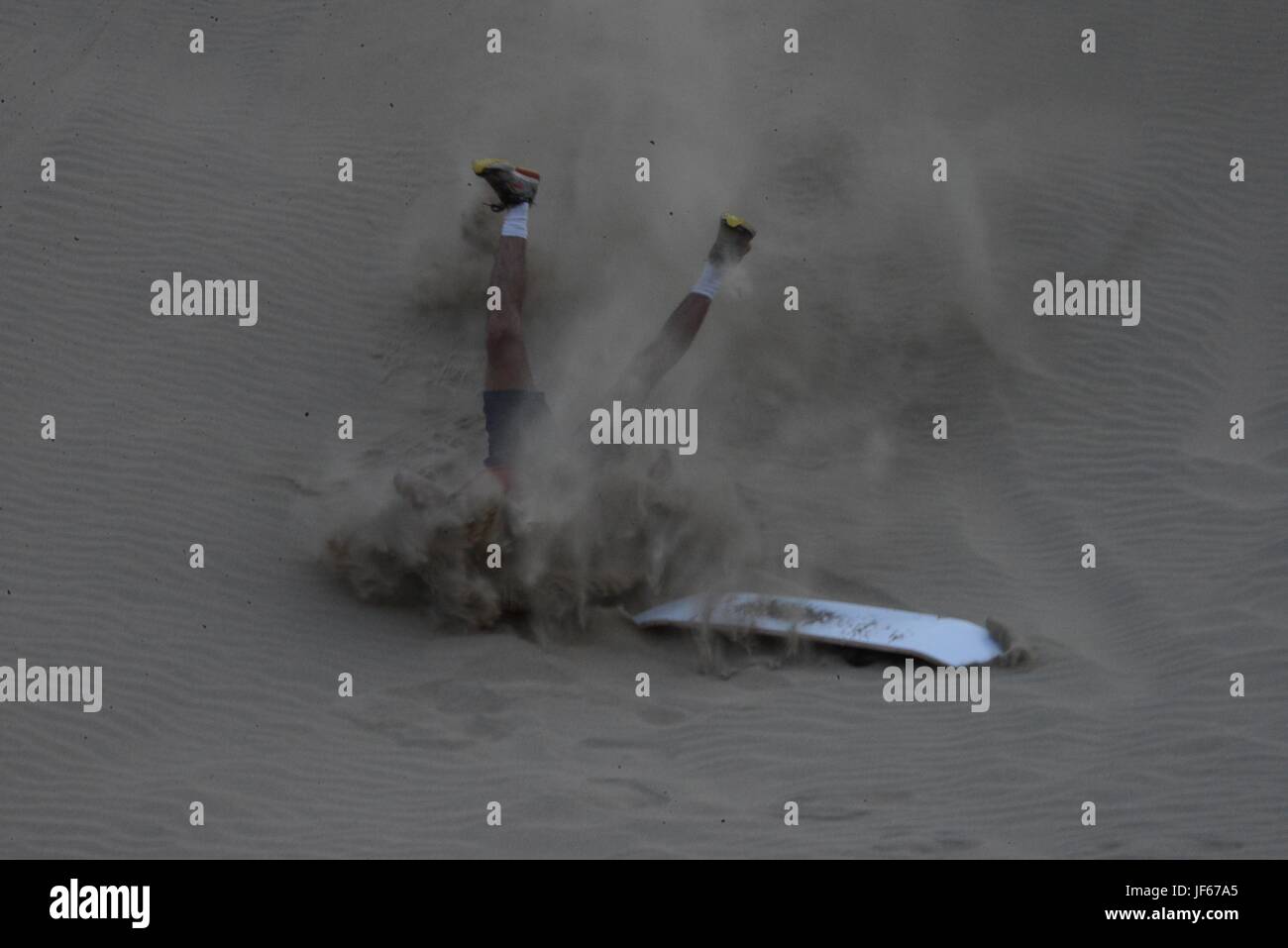 fallen beim Sand-boarding Stockfoto