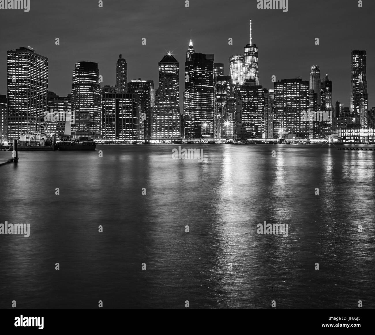 Skyline von Manhattan spiegelt sich in East River bei Nacht, New York City, USA. Stockfoto