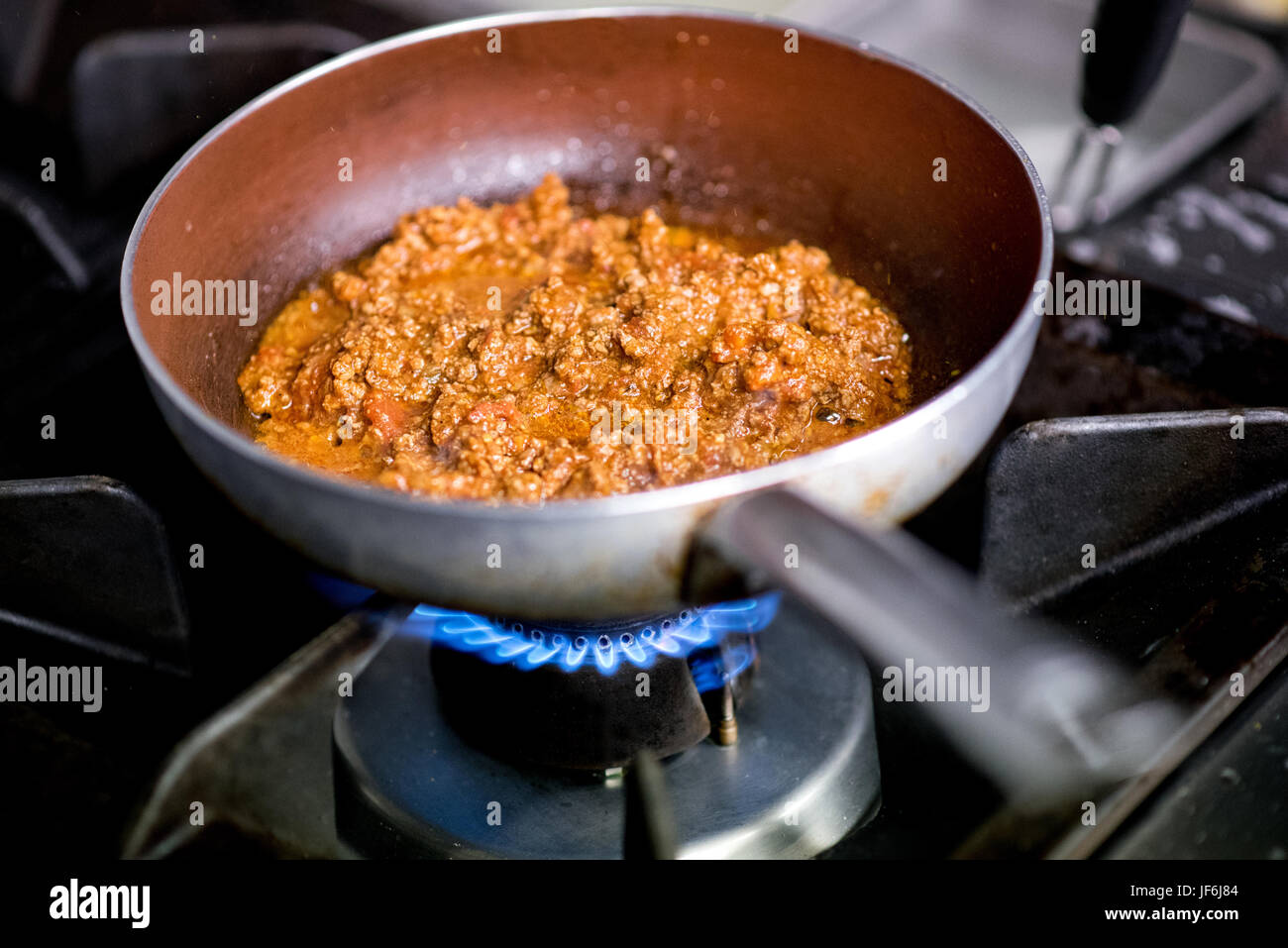 Italienische herzhaftes Ragout Fleischsoße Kochen auf einem Gasbrenner in einer Restaurantküche in Vorbereitung für ein italienische Pasta in eine enge u-Menü serviert wird Stockfoto