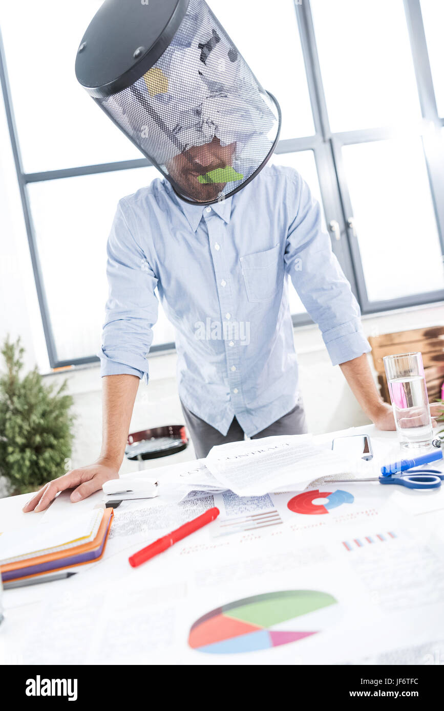 Porträt der Geschäftsmann mit Müll Eimer auf Kopf im Büro, Betriebsstätte Stockfoto