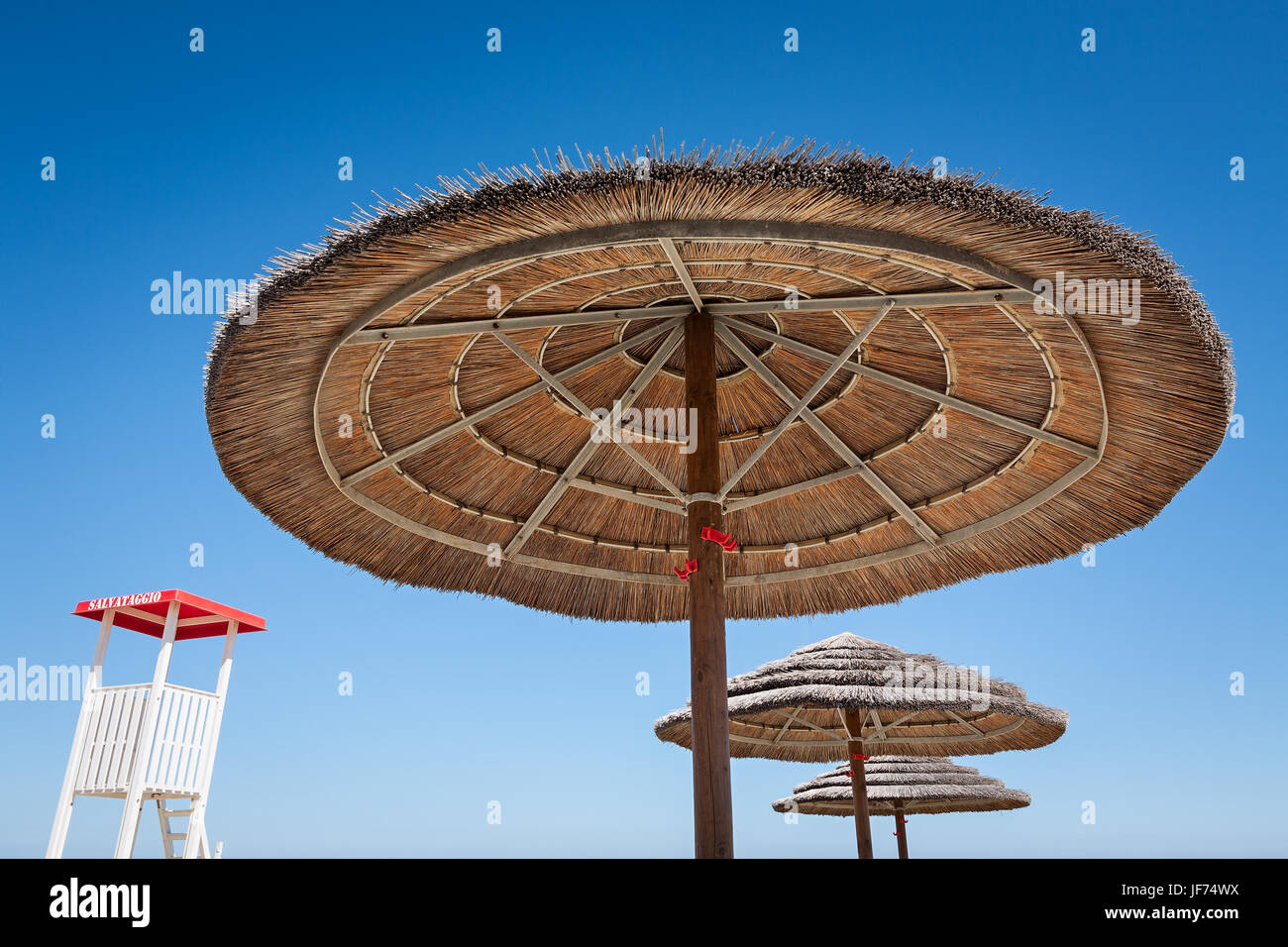 Life guard und drei Sonnenschirme Stockfoto