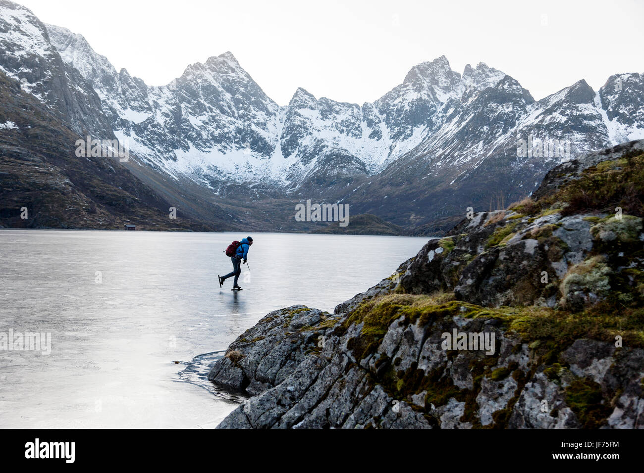 Mann, Schlittschuhlaufen auf dem zugefrorenen See Stockfoto