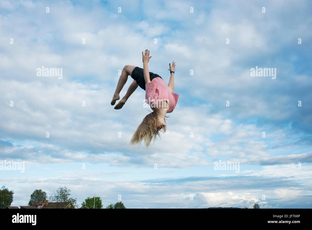 Mädchen tun Salto mitten in der Luft Stockfoto